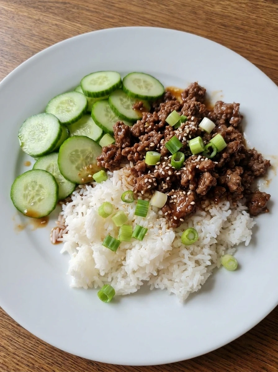 Finished Korean Ground Beef Bowl assembled with rice beef cucumber and green onions