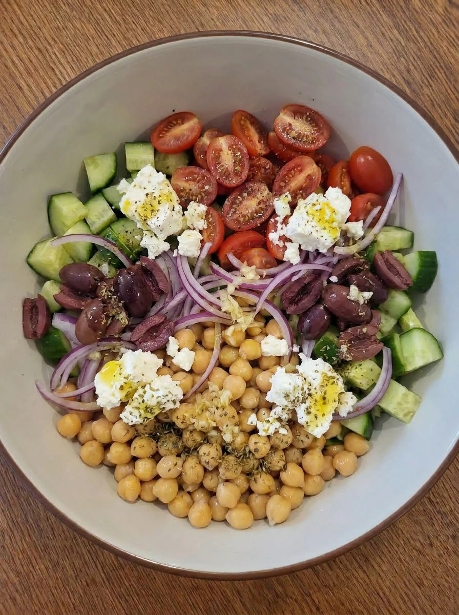 Lemon herb dressing poured over chickpea salad ingredients