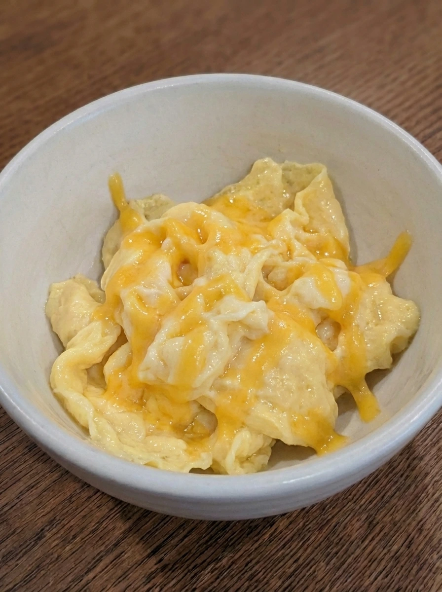 Cheddar melting over soft eggs for Egg and Cheese Breakfast Sandwich