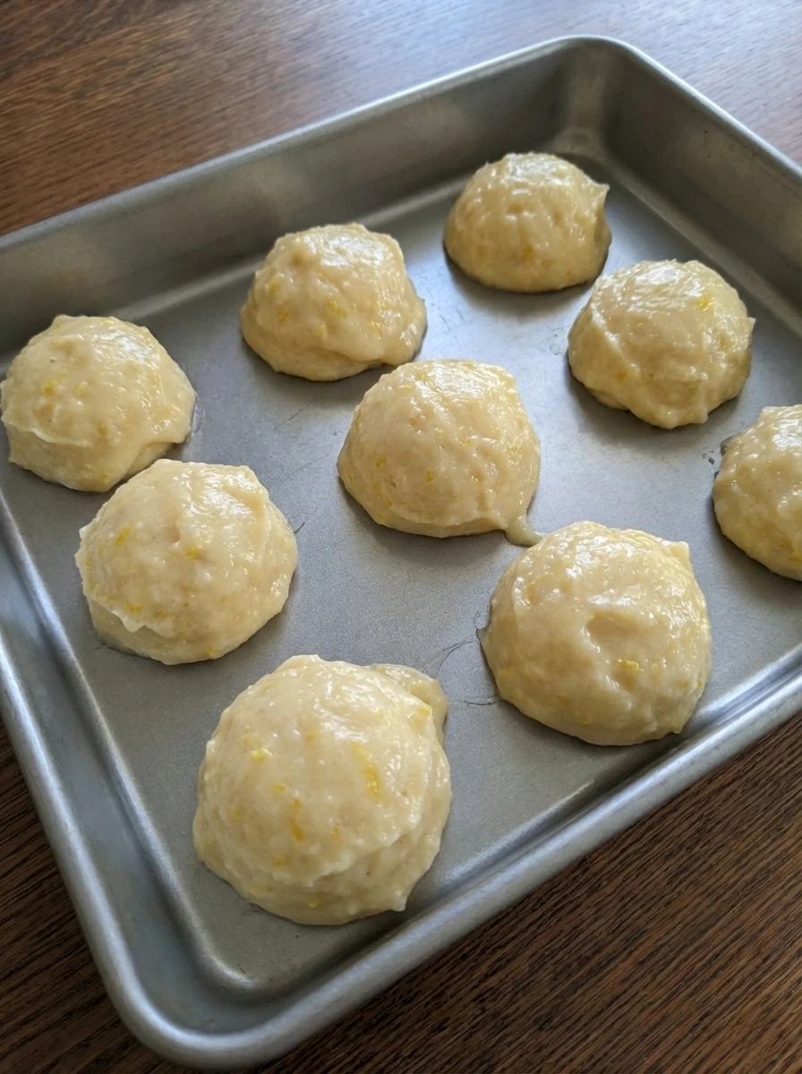 Mini lemon cake batter portioned with uneven tops