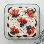 Patriotic Oreo Icebox Cake with strawberries blueberries and whipped cream.