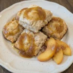 Peach Butter Swim Biscuits plated with golden edges and glossy peach swirls