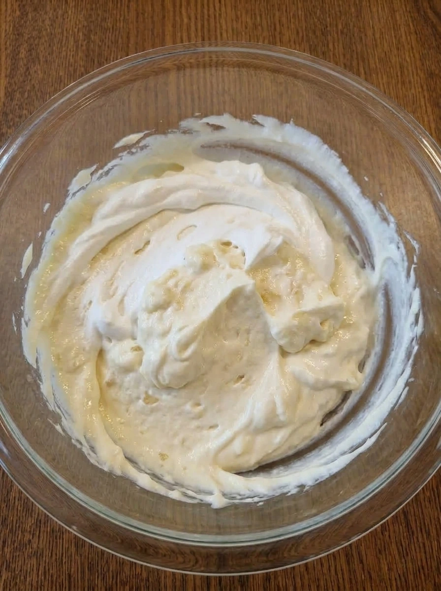 Whipped topping folded into pineapple cheesecake dip until fluffy and light.