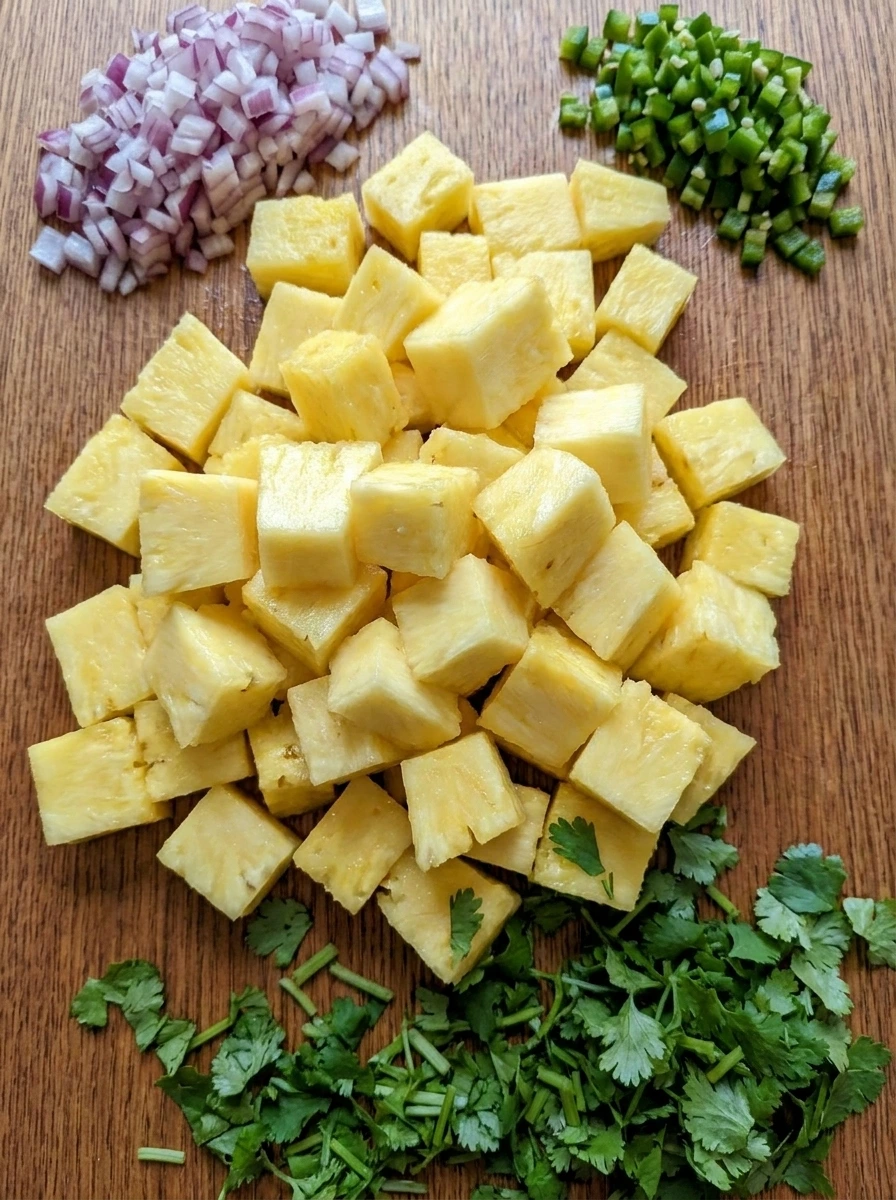 Diced pineapple red onion jalapeno and cilantro prepared for Pineapple Salsa.
