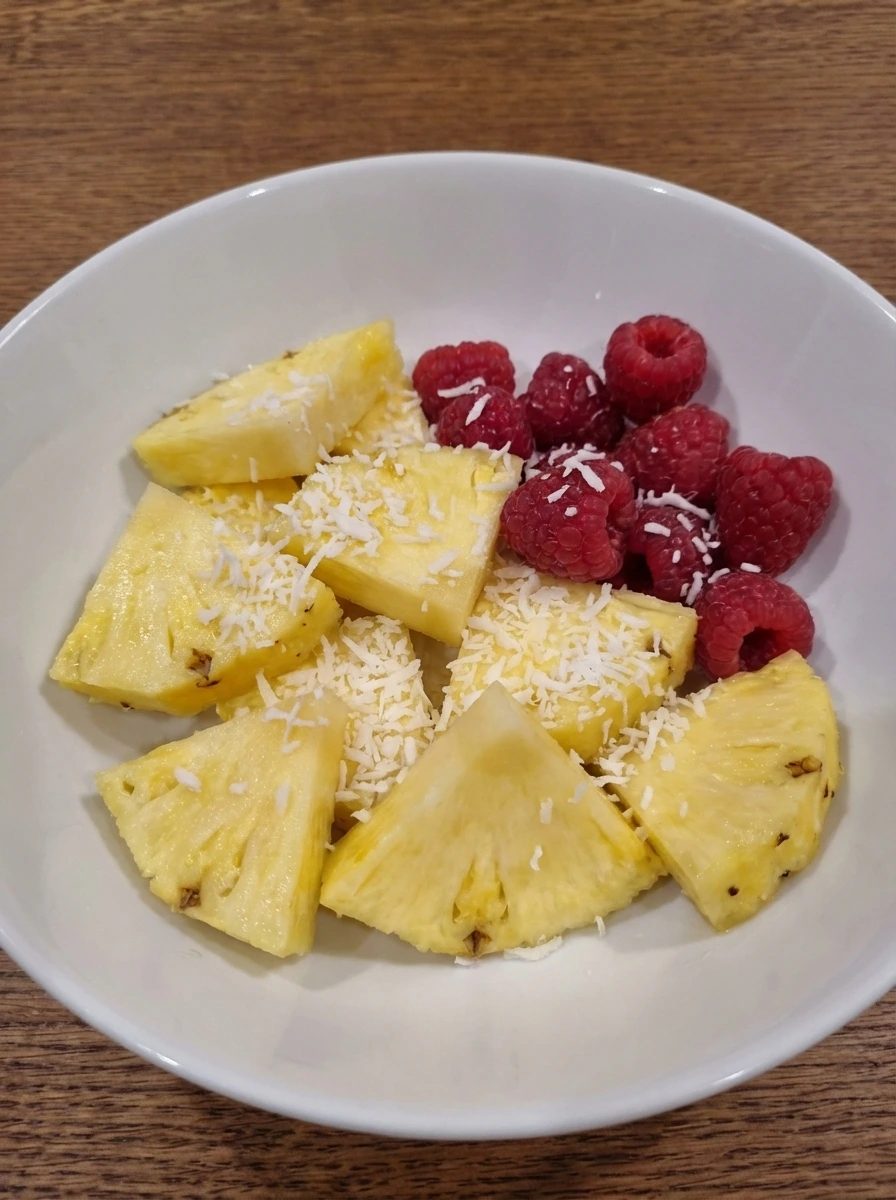 Cut pineapple wedges and fresh raspberries prepared for garnish