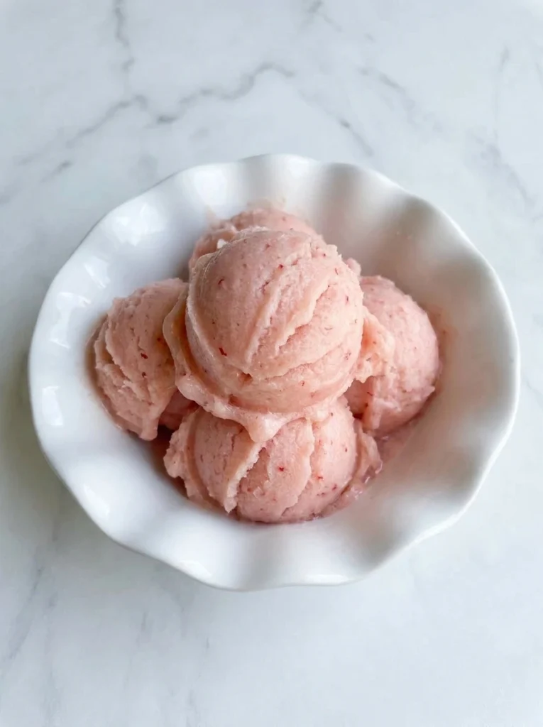 Rhubarb Sorbet with pink scoops in a white bowl