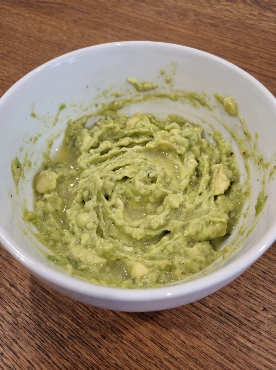 Avocado mashed with lemon and seasoning for Simple Avocado Toast