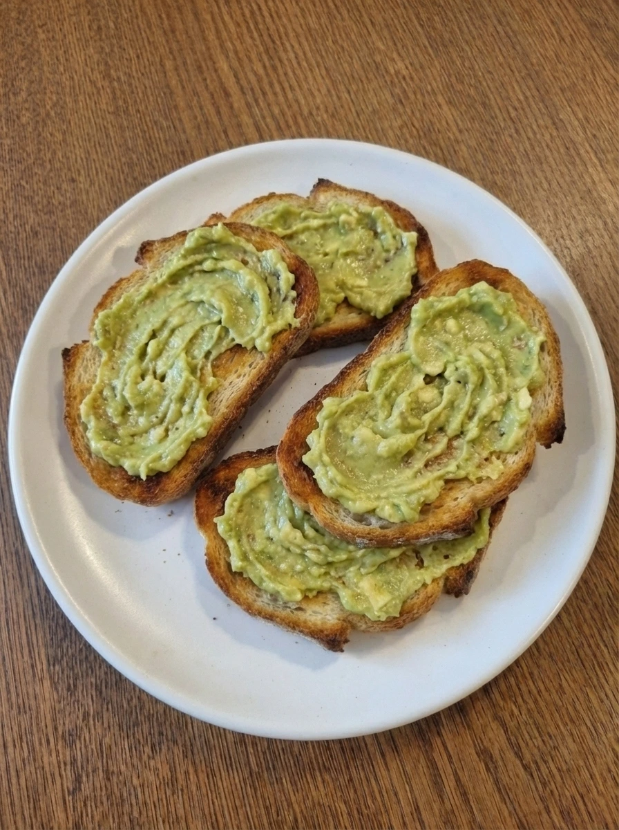 Mashed avocado spread over toasted bread for Simple Avocado Toast