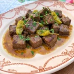 Slow Cooker Mississippi Steak Bites served on a plate with buttery pepperoncini sauce.