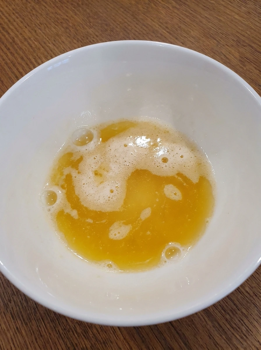 Melted foamy butter for Soft Scrambled Eggs in a white dish