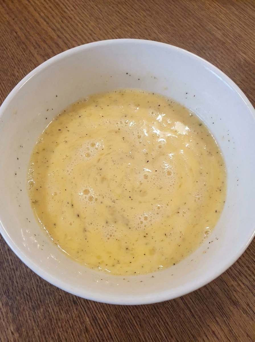 Whisked eggs with milk and seasoning for Spinach Cheese Omelette