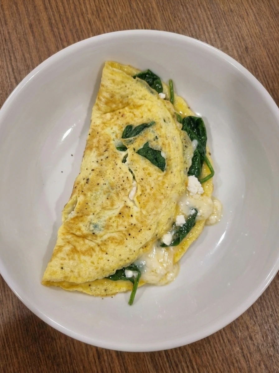 Folded Spinach Cheese Omelette with cheese starting to melt