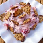 Strawberry Crackle Salad on a white scalloped ceramic plate with creamy berries and golden crackle topping