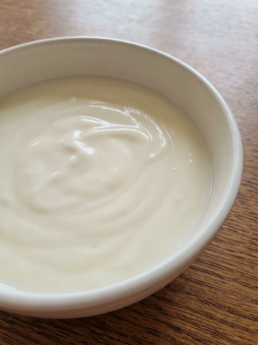 Smooth creamy base for strawberry salad in a white dish