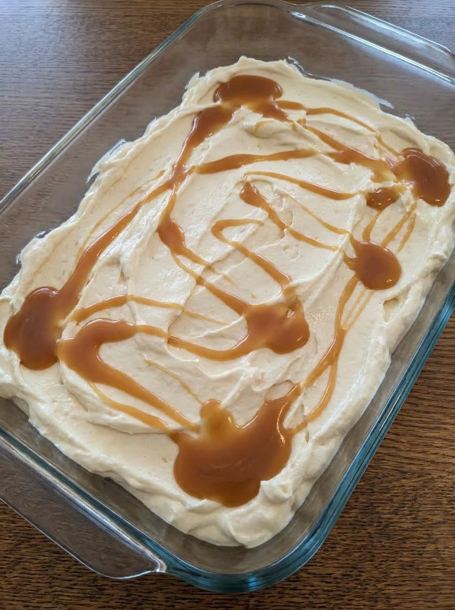 Caramel swirled into Turtle Cheesecake Dip in a serving dish.