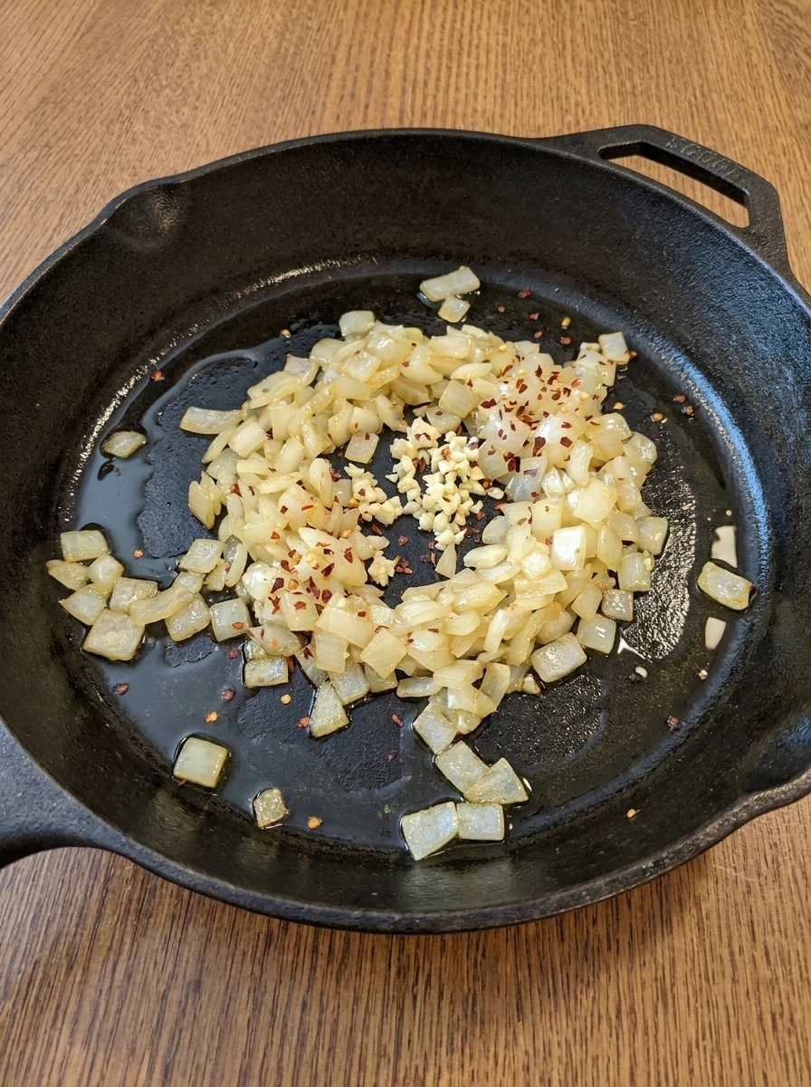 Onion garlic and red pepper flakes softening in the skillet.