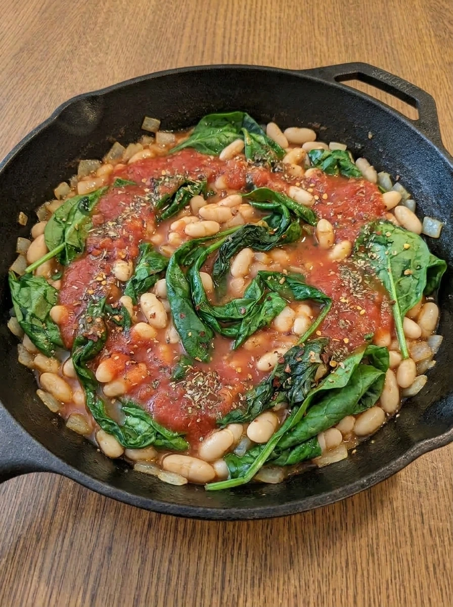 Spinach wilting into the white bean and tomato skillet.