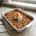 Warm Caramel Pear Crisp fresh out of the oven in a white baking dish