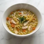 Homemade Chicken Noodle Soup with chicken noodles and carrots in bowl