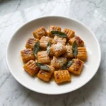Sweet Potato Gnocchi served with golden orange gnocchi pieces and sage