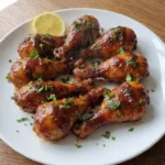 Baked BBQ Chicken Drumsticks with glossy glazed drumsticks on a serving plate Recipe focus: bbq baked chicken thighs.