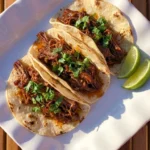Crockpot Barbacoa Beef with glossy shredded beef and lime garnish Recipe focus: slow cooker barbacoa.