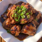 Crockpot Bourbon Chicken with glossy sauced chicken thighs in a serving bowl Recipe focus: bourbon chicken thighs.