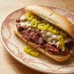 Crockpot Italian Beef Sandwiches filled with shredded beef and pepperoncini on a sandwich roll Recipe focus: slow cooker italian beef.