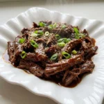 Crockpot Korean BBQ Beef with glossy tender shredded beef and green onion garnish Recipe focus: bbq beef crockpot.