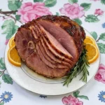 Crockpot Thanksgiving Ham with glossy glazed spiral slices on a serving plate Recipe focus: thanksgiving ham recipes crockpot.