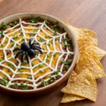 Halloween Appetizers Dip in a round bowl with spooky spiderweb topping