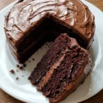 Moist Chocolate Cake with glossy chocolate frosting and a sliced soft crumb Recipe focus: chocolate zucchini cake.