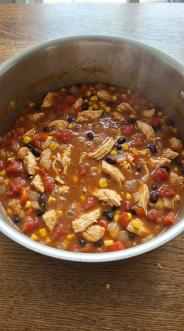 Chicken Taco Soup simmering with chicken beans tomatoes and corn Recipe focus: taco soup recipe.