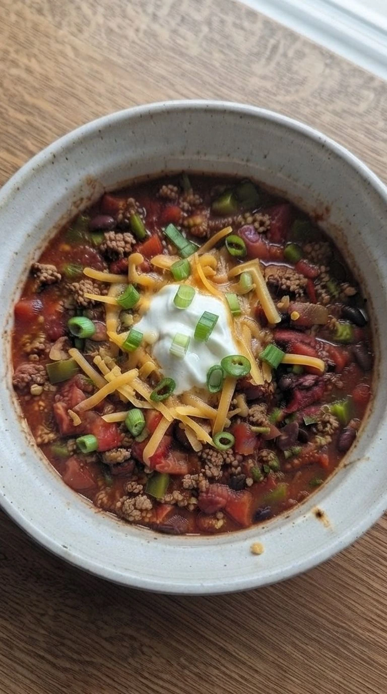 Crockpot Chili in a bowl with thick beef, beans, and rich tomato texture Recipe focus: chili recipe.