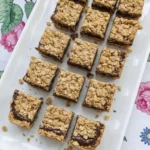 No Bake Chocolate Oat Bars cut into uneven squares with chewy oat layers and a fudgy chocolate center. Recipe focus: easy no bake dessert bars.