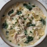 White Chicken Lasagna Soup with creamy broth, chicken, noodles, and melted cheese in a bowl Recipe focus: white lasagna soup.