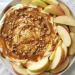 Cream Cheese Caramel Apple Dip with caramel swirls and apple slices ready to serve Recipe focus: caramel apple cheesecake dip.