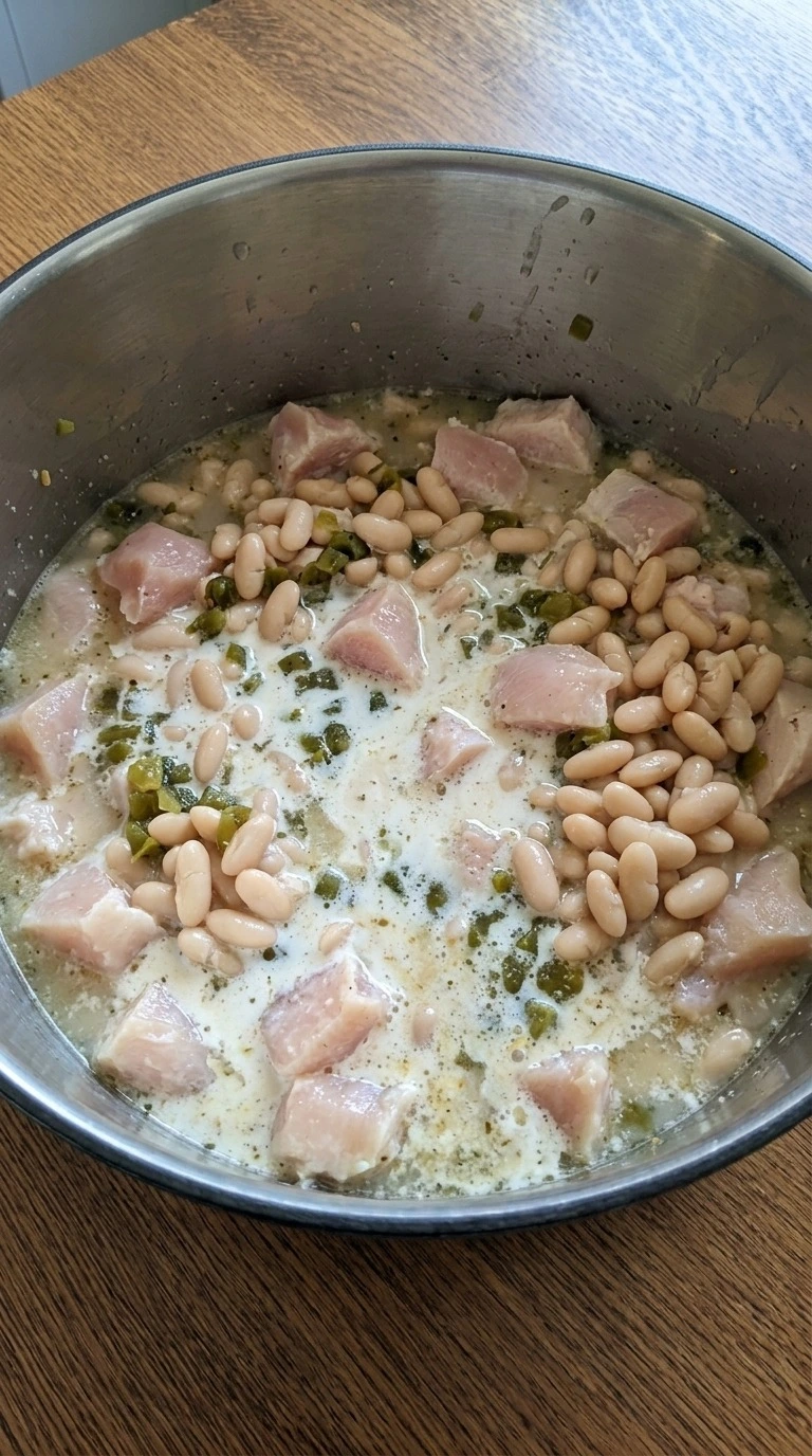 Creamy White Chicken Chili ingredients combining in a pot before thickening Recipe focus: instant pot white chicken chili.