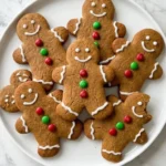 Gingerbread Man Cookies with white icing faces and colorful buttons arranged on a white serving plate Recipe focus: gingerbread cookies.