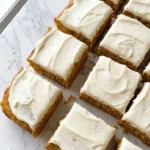 Pumpkin Bars with Cream Cheese Frosting cut into homemade squares with creamy topping Recipe focus: pumpkin bars recipe.