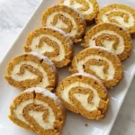 Pumpkin Roll with Cream Cheese Filling sliced to reveal soft pumpkin cake and a thick cream cheese spiral. Recipe focus: pumpkin roll recipe.