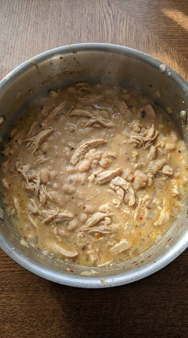 White Bean Chicken Chili simmering with white beans and shredded chicken in thick broth Recipe focus: crockpot white chicken chili.